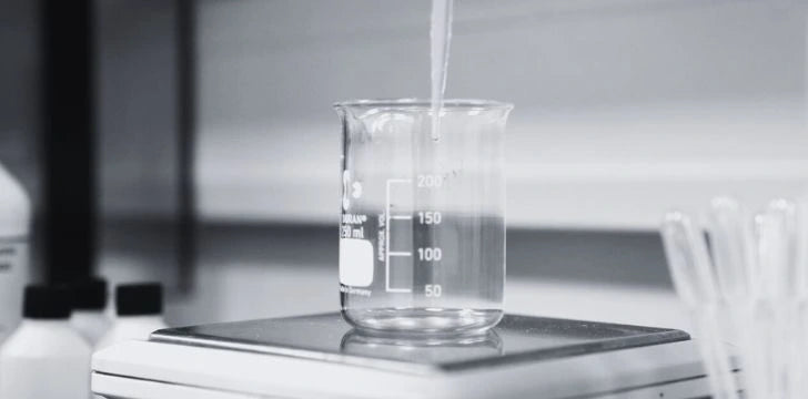 Beaker being filled with liquid on a scale in a laboratory setting