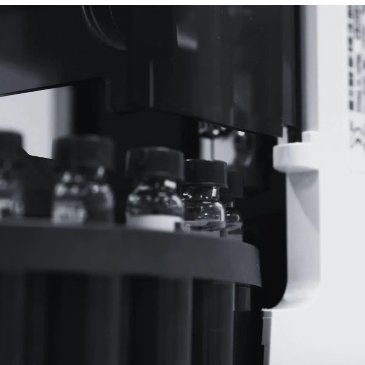 Close-up of a machine with jars on a table, black and white photo