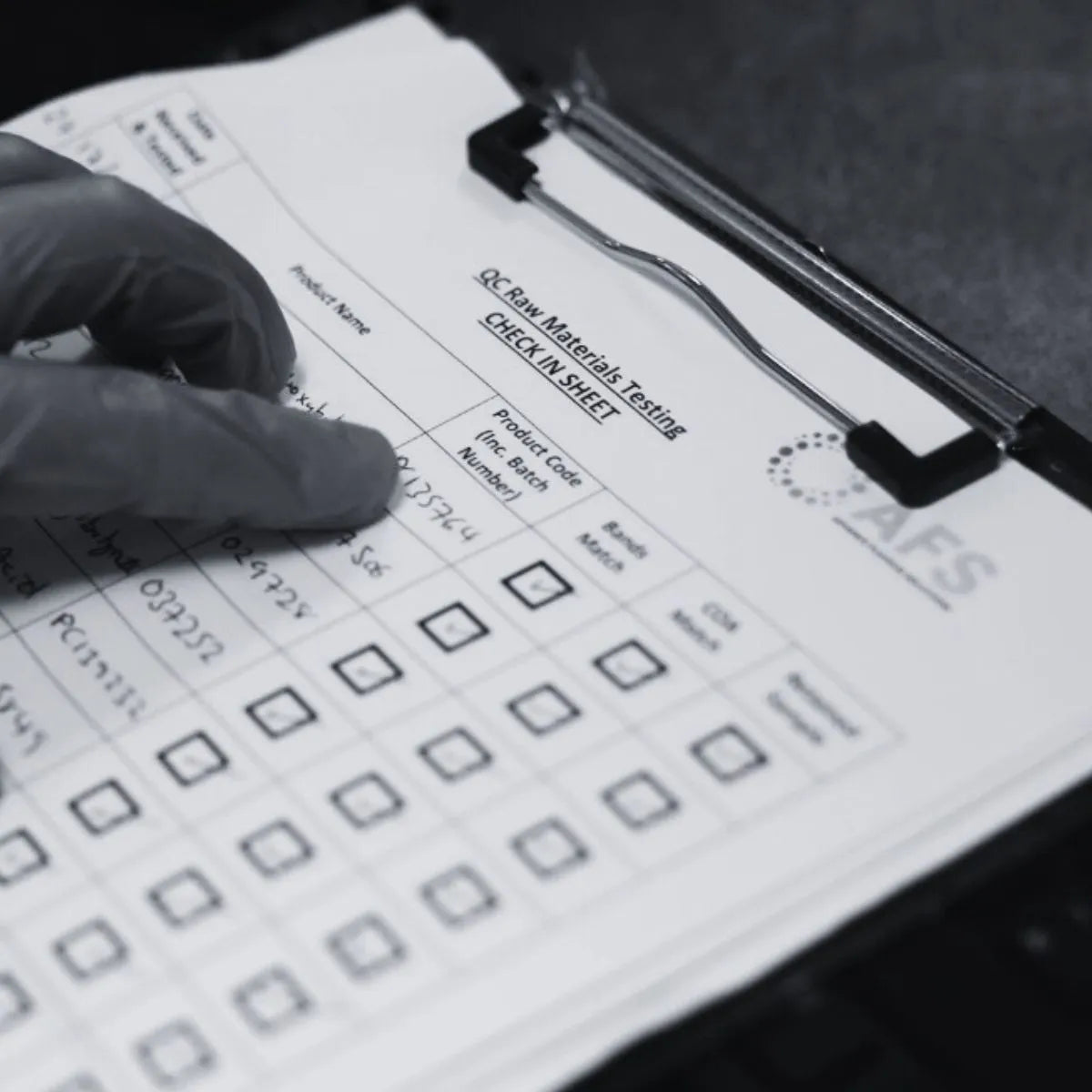 Person wearing a glove filling out a check-in sheet with checkboxes on a clipboard.